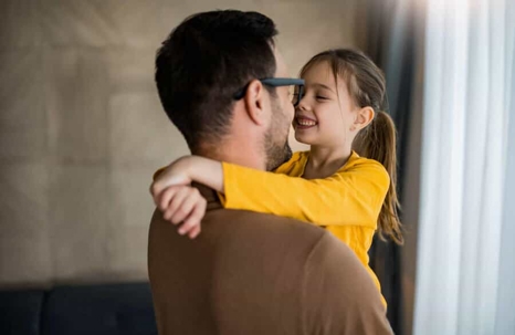 man holding his daughter smiling